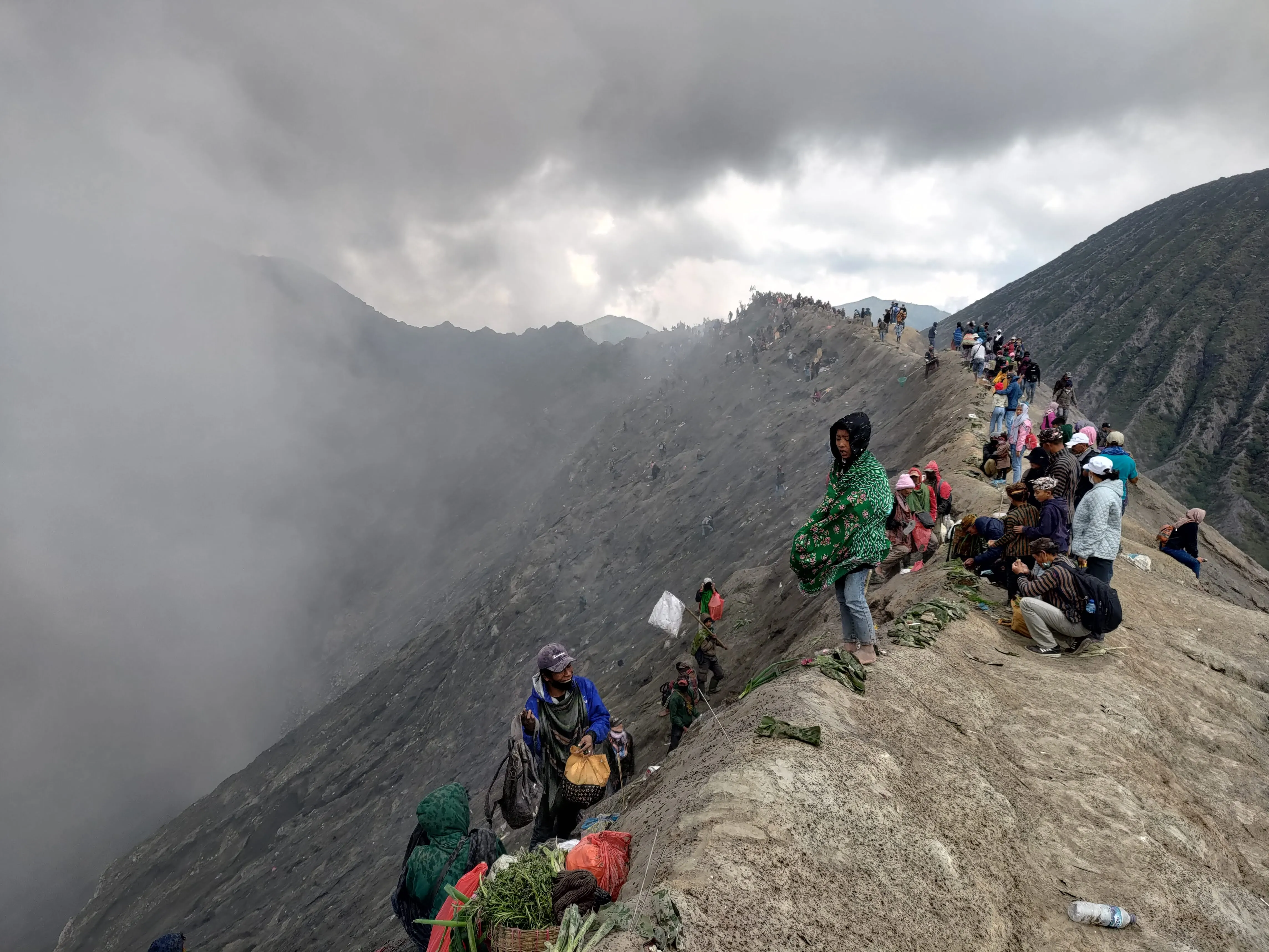 Mount bromo crater lined with people paying tributes in a festival
